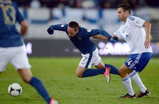 French forward Franck Ribery (C) is tackled by Finland's midfielder Tim Sparv